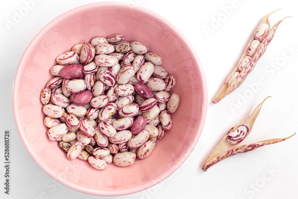 Fototapeta Cranberry beans on an isolated white background. Cranberry beans inside and outside the pink bowl.