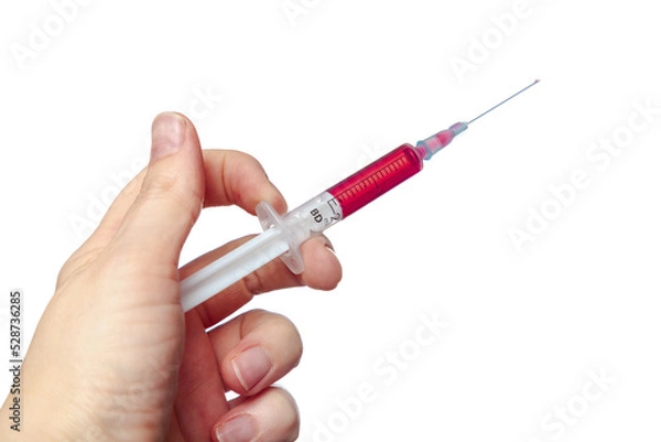 Fototapeta Hand holding a syringe with red medicine....