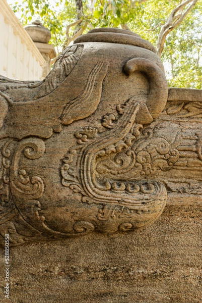 Fototapeta Korawakgala or wing stones are stone balustrades, which are located on either side of the stairs/steps leading to the entrance or door of a religious building or structure.