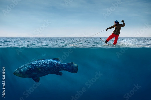Fototapeta Snowboardzista surfujący po falach z rybą na smyczy
