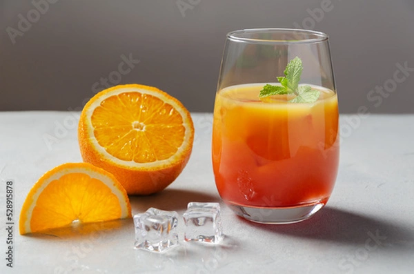 Obraz Classic Garibaldi alcoholic cocktail with campari, orange juice, ice and slice of orange or mocktail on a background