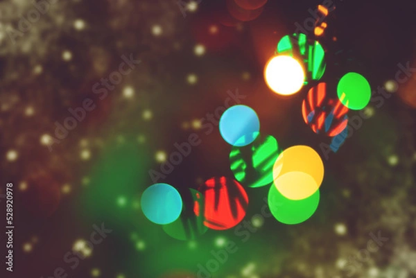 Fototapeta Festive background with blurred lights. A postcard on the theme of winter holidays.