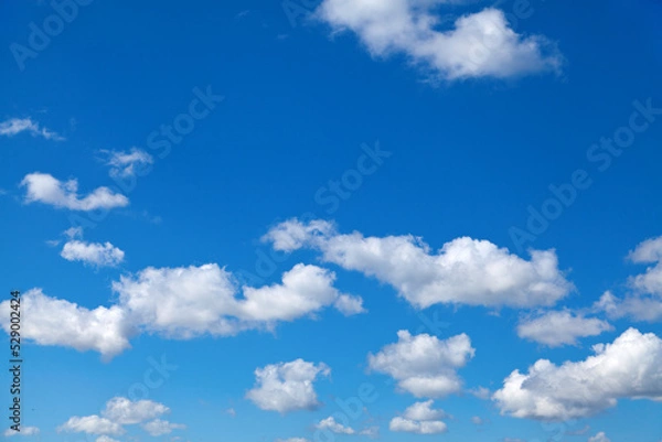 Obraz Fluffy white clouds in blue summer sky, perfect background.
