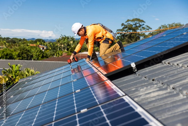 Obraz Solar panel technician with drill installing solar panels