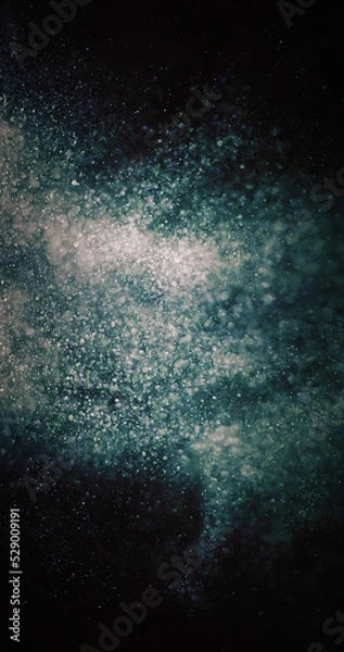 Fototapeta Particles background. Dust splash. Cosmic collision. Defocused green blue white bubbles burst on dark night black abstract wallpaper.