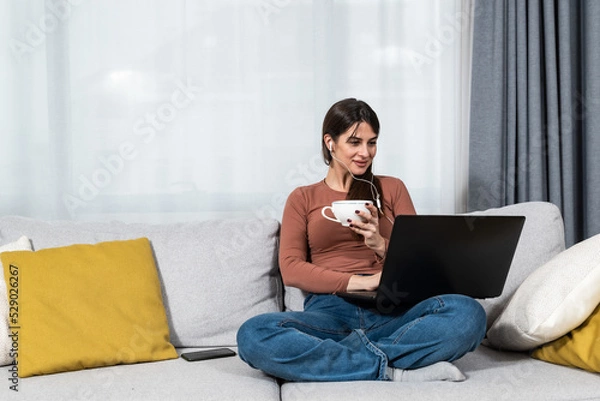 Fototapeta Young woman high school professor or elementary school teacher having online classes with her students from her home. Private lessons on online education video call on laptop computer.