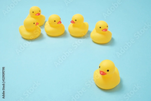 Obraz 水色背景にランダムに並ぶ黄色くてかわいいアヒルのヒヨコの置物