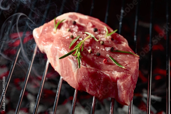Fototapeta Raw steak on a grill.