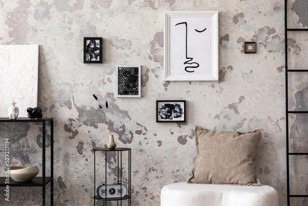 Obraz Interior design of harmonized living room with design white pouf, decorations, carpet, mock up poster frames and elegant personal accessories. Concrete grunge wall. Minimalist home decor. Template.	