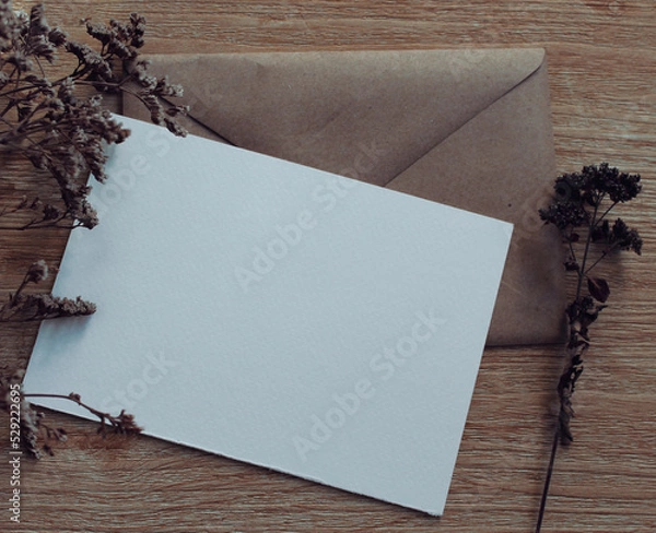 Fototapeta Minimalistic card mockup with  dried flowers, craft envelope. Invitation card with environment and plants