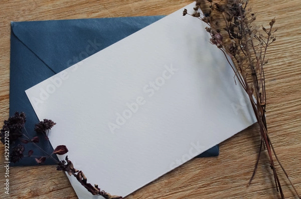 Fototapeta Minimalistic card mockup with  dried flowers, craft envelope. Invitation card with environment and plants