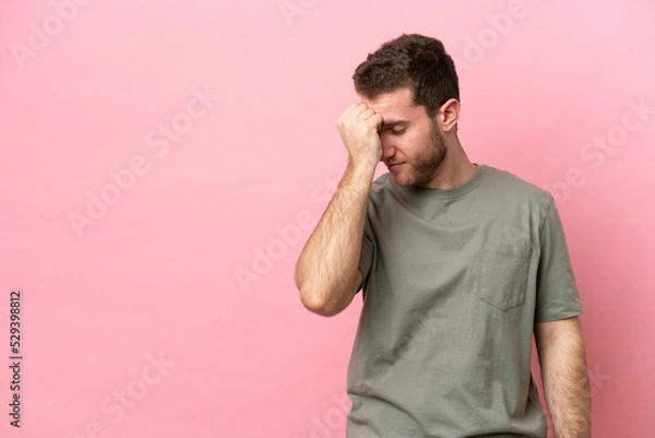 Fototapeta Young caucasian man isolated on pink background with headache