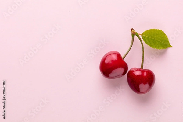 Obraz Cherry berries on a pastel background top view.  Background with a cherry on a sprig, flat lay