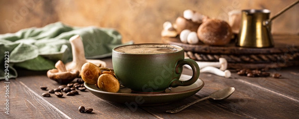 Fototapeta Banner with mushroom coffee in green cup on wooden background. New Superfood trendy healthy concept with copy space, selective focus.