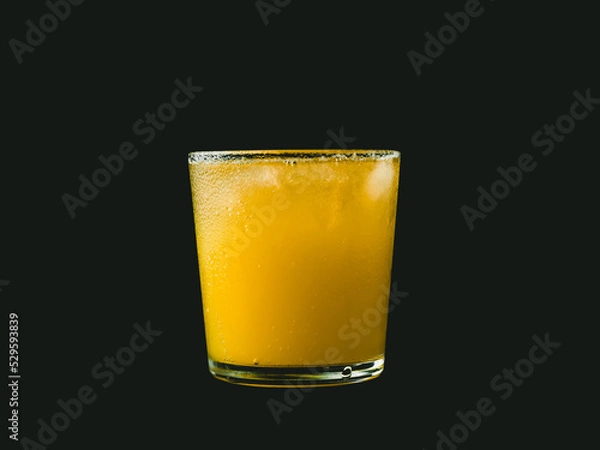 Obraz Citrus juice on dark background.