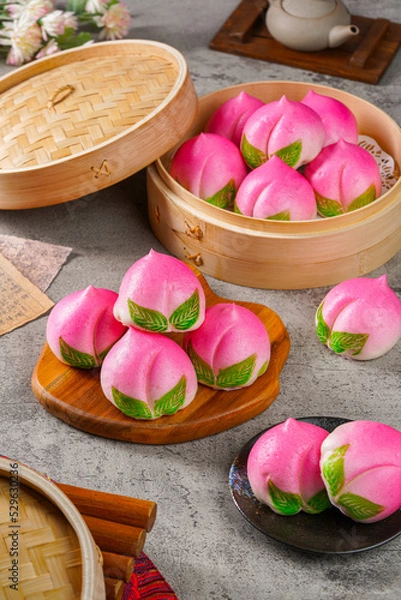 Fototapeta Sienthou  peach is a symbol of longevity. Baozi or Bakpao is a type of yeast-leavened filled bun in various Chinese cuisines.
