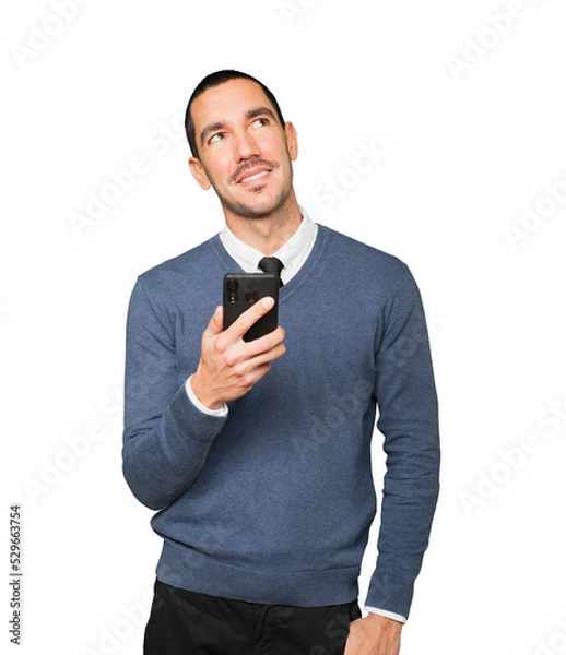 Fototapeta Happy young man looking up and using a mobile phone