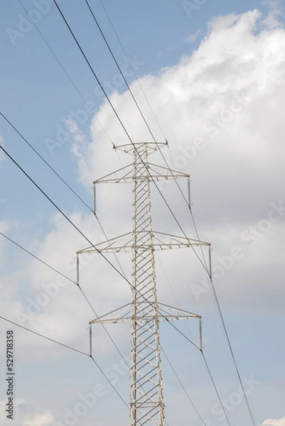 Fototapeta high voltage mast with power lines, sky with white clouds, no person and vertical format