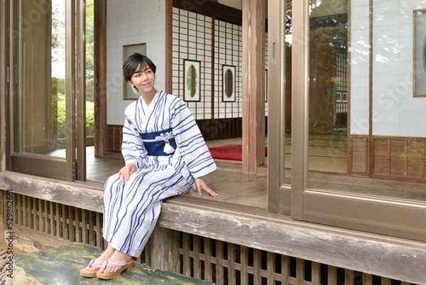 Obraz 古民家の縁側に座り微笑む浴衣を着た若く綺麗な女性