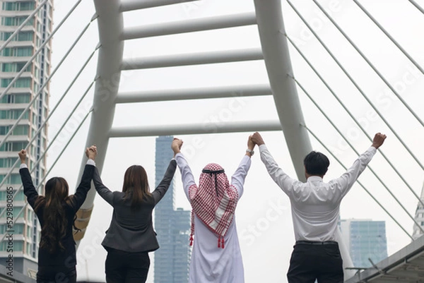 Fototapeta happy business team making high hands in sunset sky background for business teamwork concept