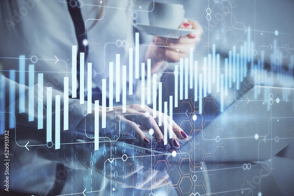 Fototapeta Double exposure of businesswoman hands typing on computer and financial graph hologram drawing. Stock market analysis concept.