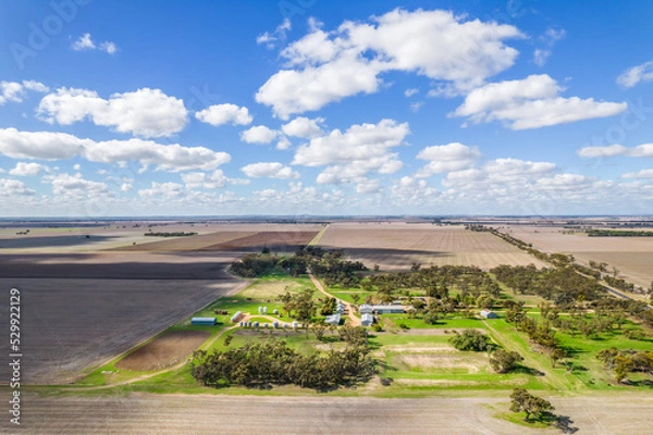 Obraz Looking down on a farm property on a cloudy day casting shadows