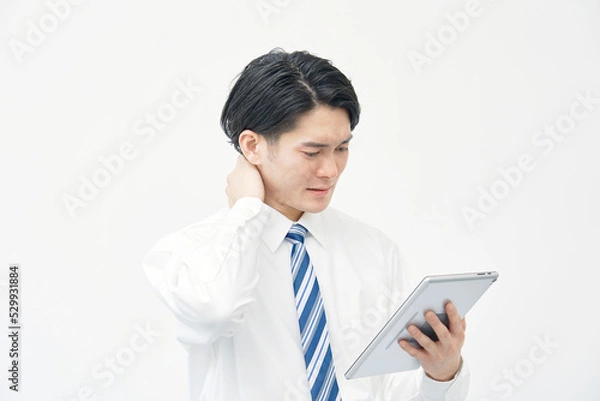 Fototapeta タブレットを見て悩むビジネスマン　白背景