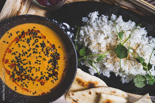 Obraz Zupa z dyni z ryżem, chlebkiem naan, i czarnym sezamem