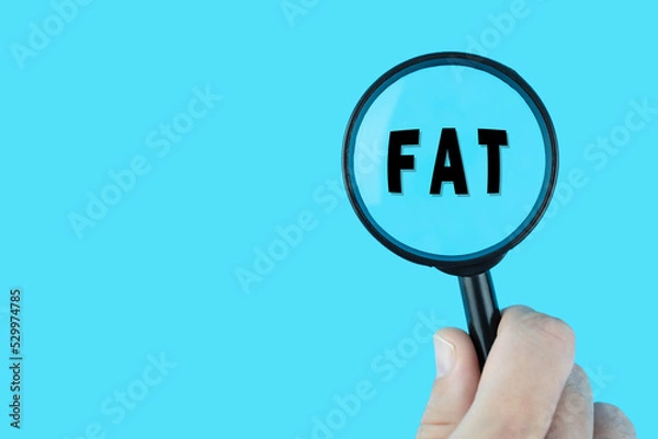 Fototapeta Focused on diet and ratio of protein, fats and carbohydrates. Word fat under magnifying glass. Nutrition research. 