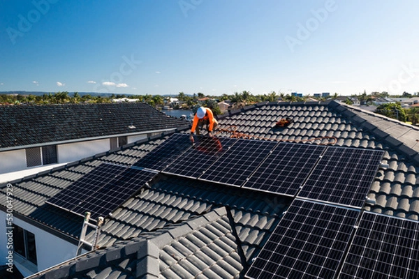 Obraz Solar panels and technician on luxury waterfront home
