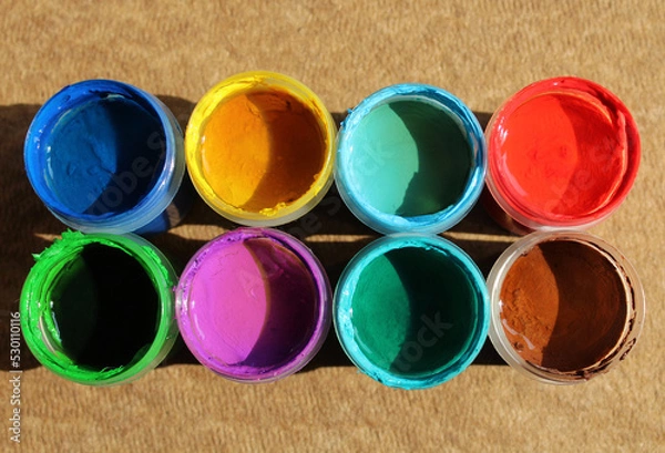 Fototapeta Acrylic paints in jars. Top view photo of opened pots with different colors of paint 