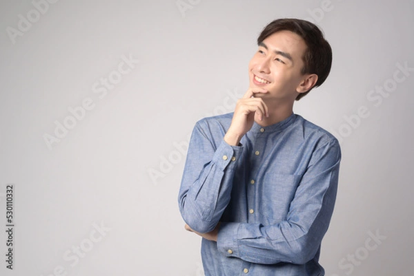 Obraz Portrait of young asian man over white background studio.
