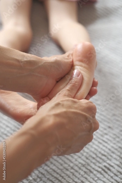 Obraz Masseur hands gives foot massage to a child. Sensual touching 