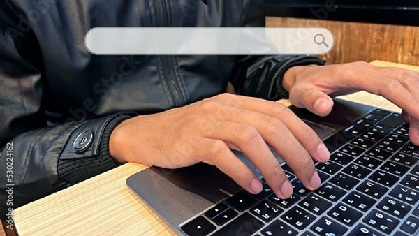 Fototapeta Hand of business executive using laptop at desk in office
