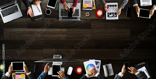 Obraz Top view of business Group of Multiethnic Busy People meeting with other in modern office with laptop computer, smartphone, tablet, coffee and document on table..