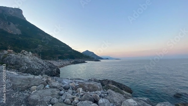 Fototapeta Landscape of the south of Italy from a boat at sunset with high hills, sea till the line of the horizon with past colour in a sunny day