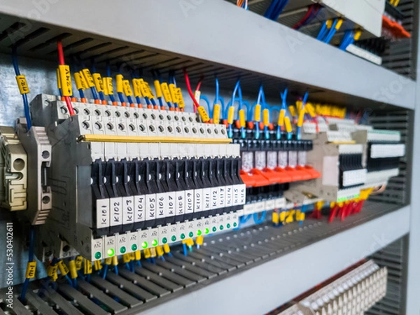 Fototapeta Row of fuses and relays installed in electrical cabinet automation system in industrial plant.