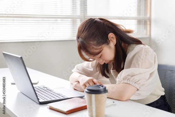 Obraz 仕事が忙しく疲れてしまった女性。働きすぎで居眠りをしている。