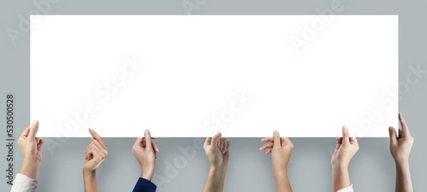 Fototapeta Many hands holding a long blank poster for advertising on grey background.