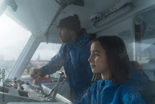 Fototapeta Man and children manning a ship from the control cabin