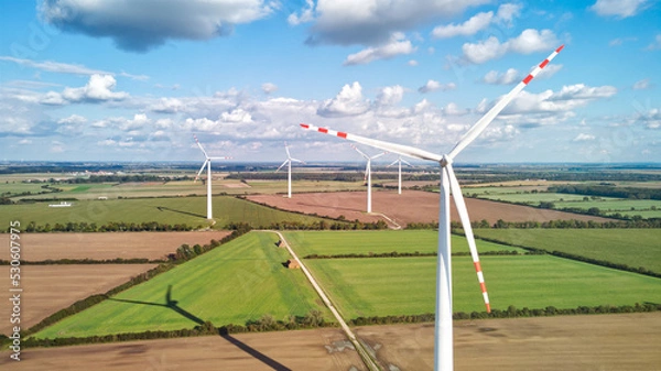 Fototapeta Drone aerial view of wind farm with wind turbines generating electricity. Image with copy space.
