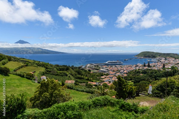 Fototapeta View over Horta to the Pico volcano / View over the town of Horta on the island of Faial, a cruise ship is moored in the harbor, on the horizon you can see the Pico volcano, Azores, Portugal.