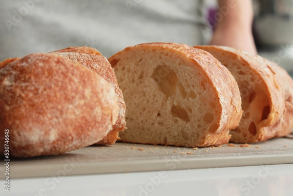 Fototapeta Sliced loaf of bread on a chopping board