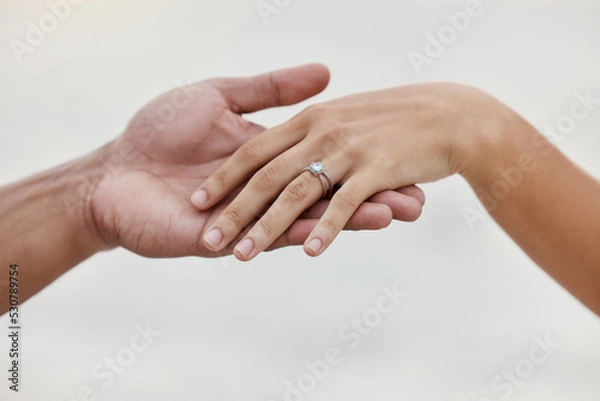 Fototapeta Engagement ring, hands and proposal of engaged couple romantic marriage celebration. Zoom on diamond jewelry finger for love, save the date and announcement of special occasion in commitment together