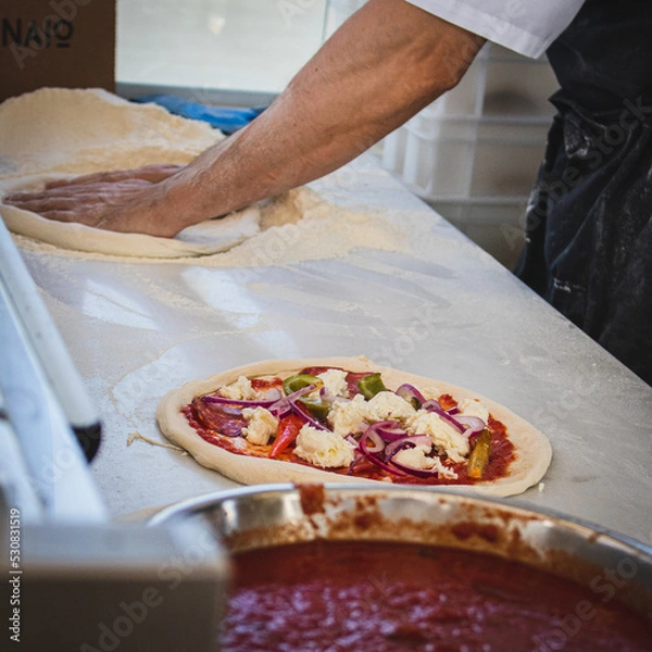 Obraz Italian pizza chef preparing and cooking pizza with mozzarella cheese tomato sauce and fresh basil leaf