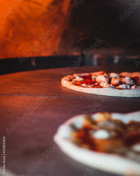 Obraz Italian pizza chef preparing and cooking pizza with mozzarella cheese tomato sauce and fresh basil leaf