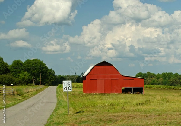 Obraz Red barn blue sky speed limit sign