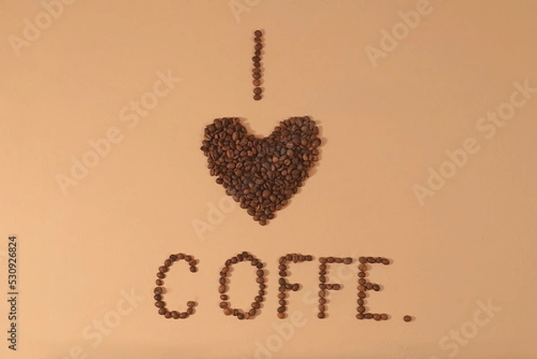Fototapeta Heart shaped roasted coffee beans and text i love coffee on beige background,top view,flat lay,minimal creative concept,advertising for modern coffee shop,cafe,bar,