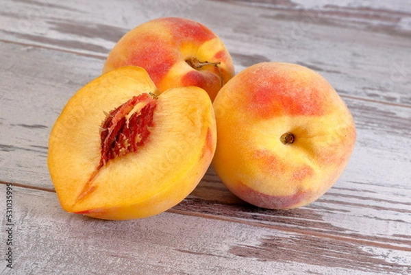 Fototapeta View of a bunch of peach fruits on wooden background.