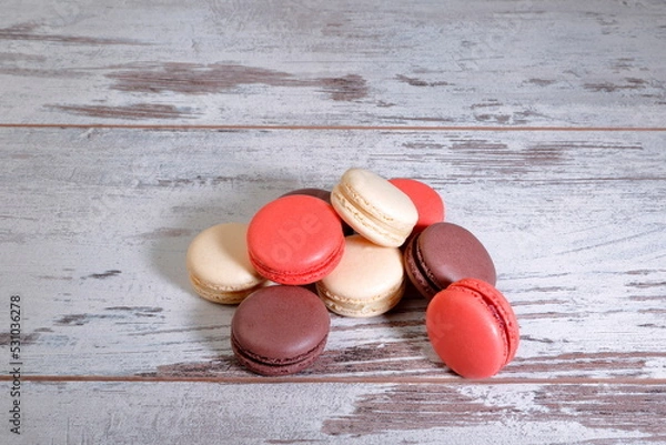 Fototapeta Cocoa, strawberry and almond macarons on wooden background.